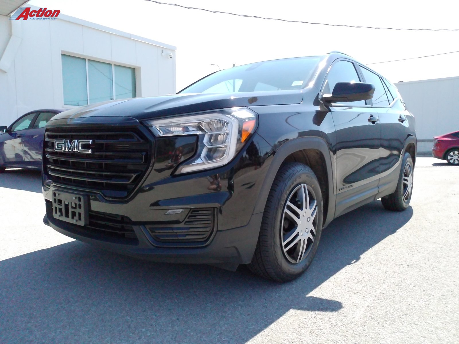 Black GMC SUV parked outside a dealership with a clear view of the front and side.