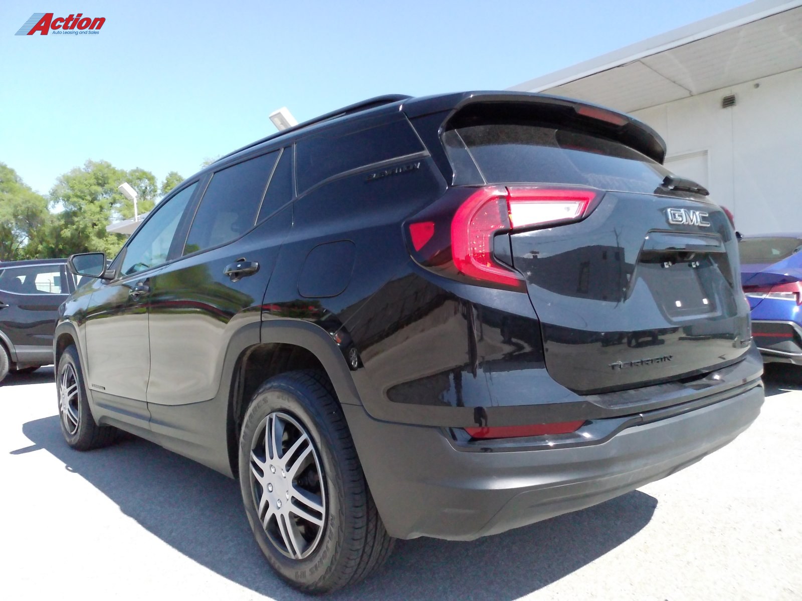 Black SUV parked at a dealership, showcasing its rear and side profile.