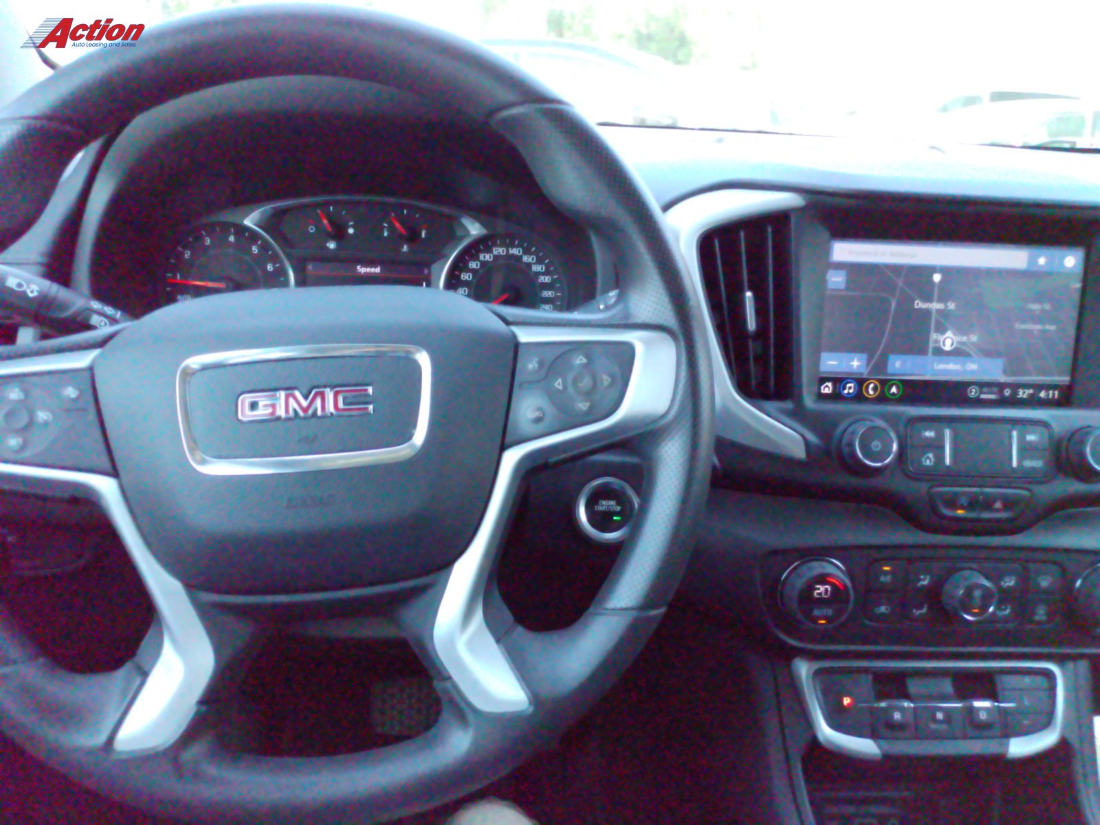 GMC vehicle interior showcasing the steering wheel and dashboard with infotainment system.
